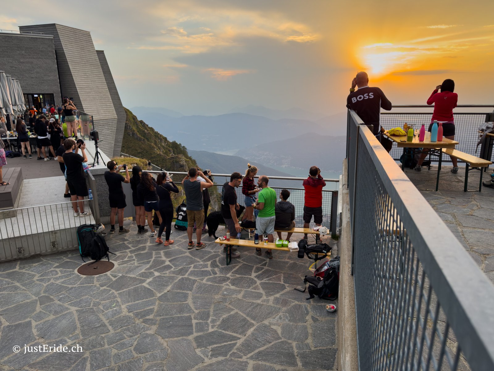 Participants enjoying the solar eclipse sunset from the Monte Generoso summit terrace with panoramic views over Mendrisiotto.
